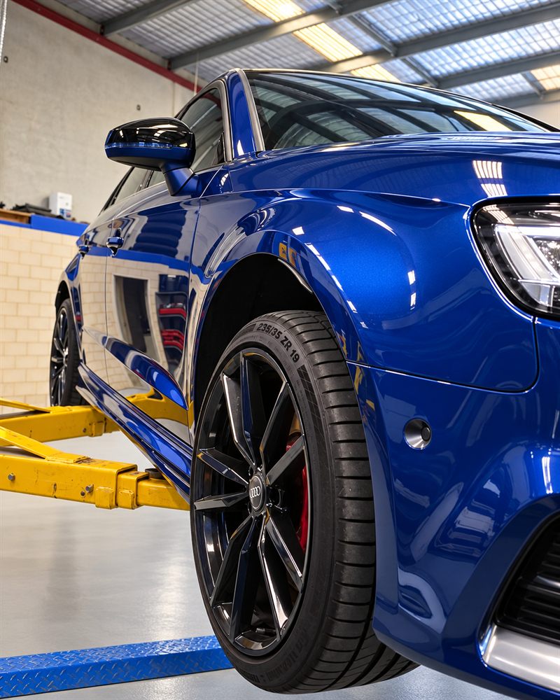 Blue Audi RS3 front wheel and brake on the hoist