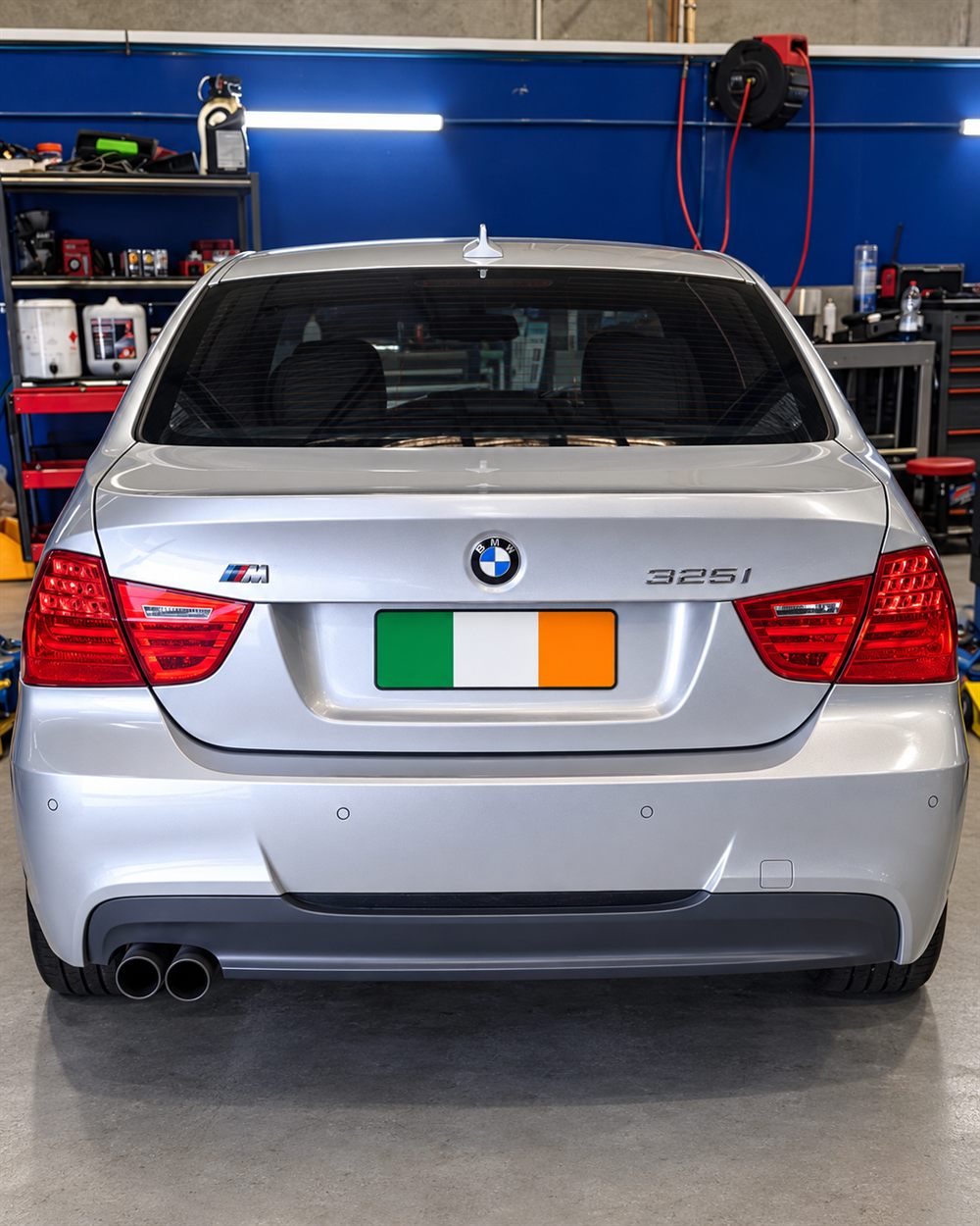 Rear of a silver BMW 325i in the workshop