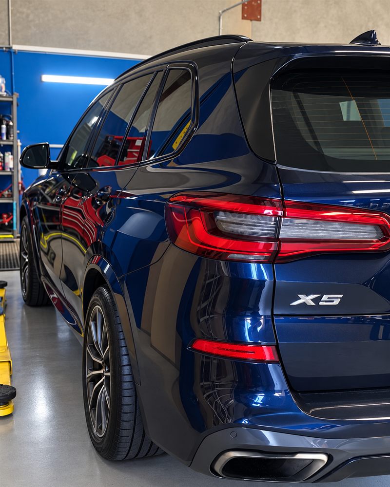 Blue BMW X5 rear three-quarter view