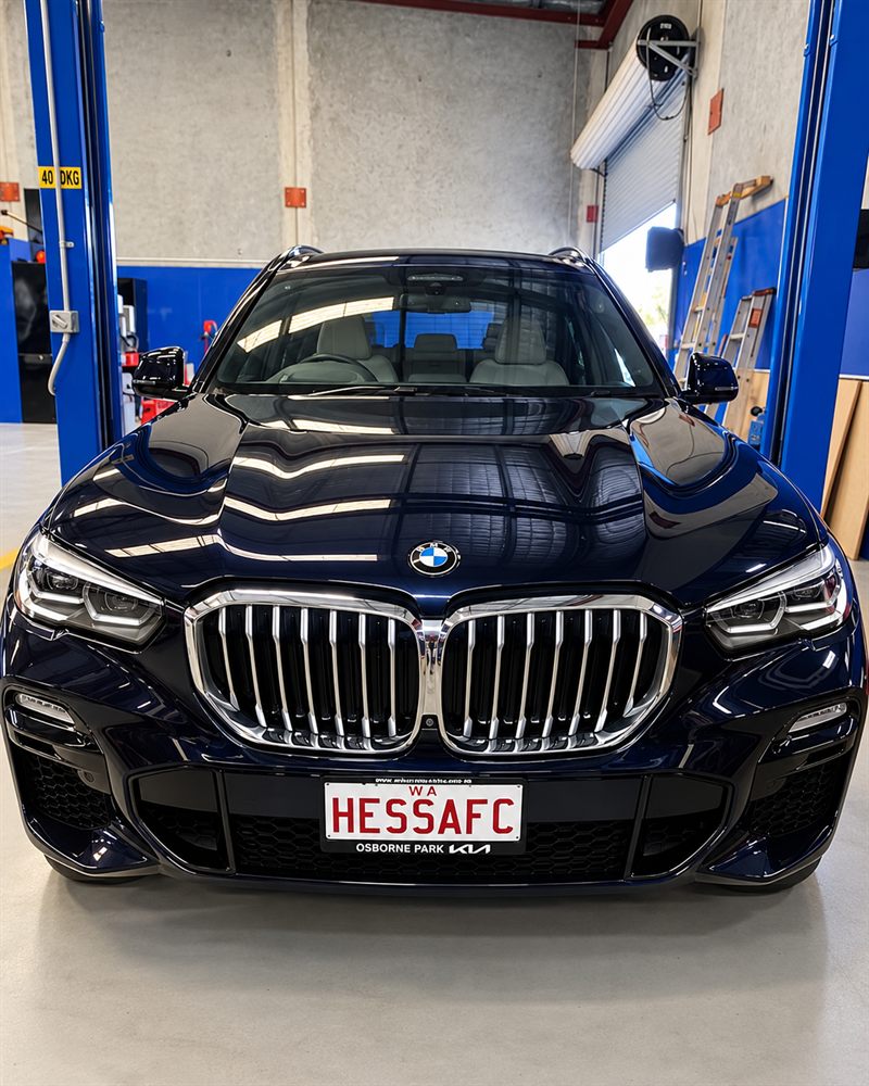 Blue BMW X5 front view in the workshop