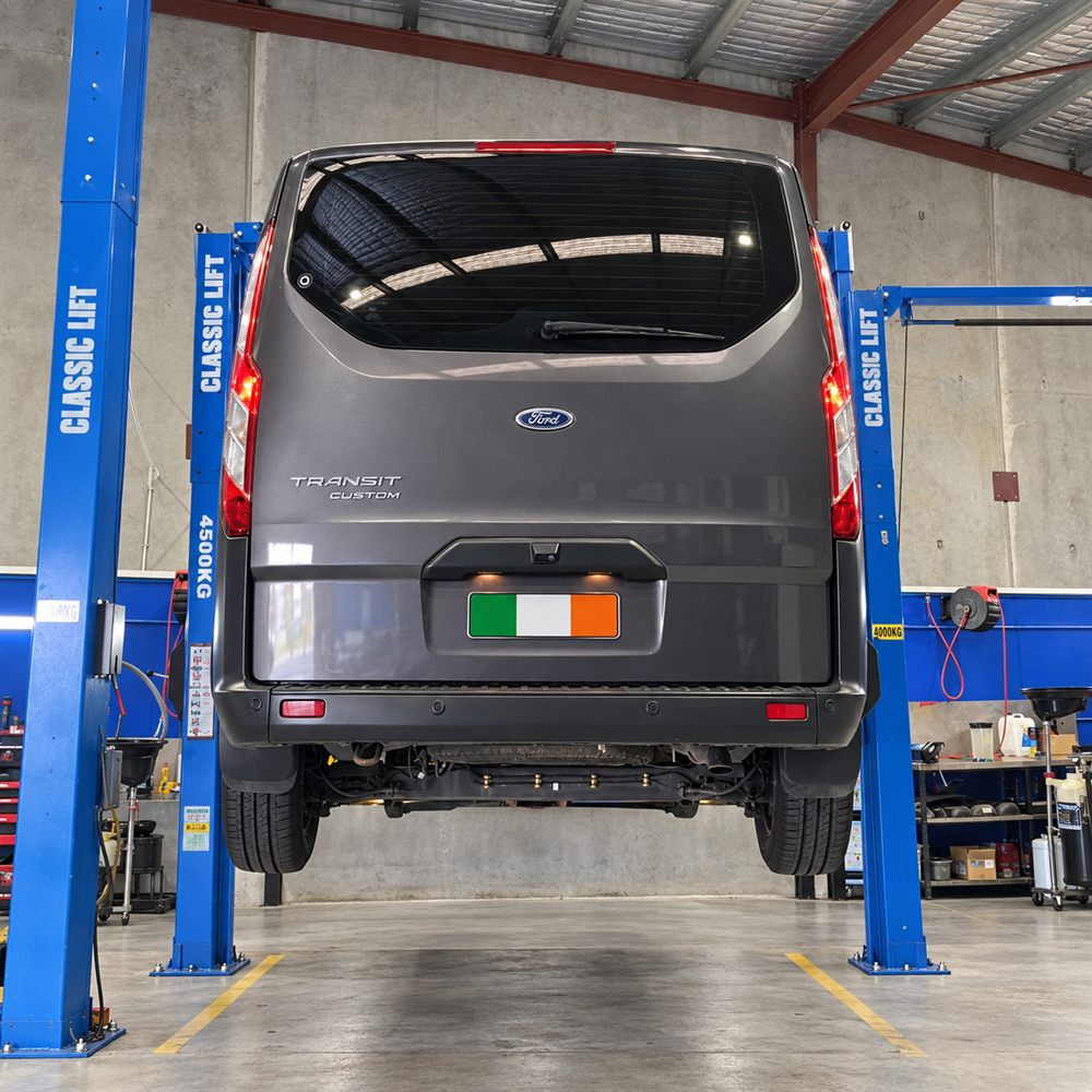 Grey Ford Transit Custom van raised on a hoist