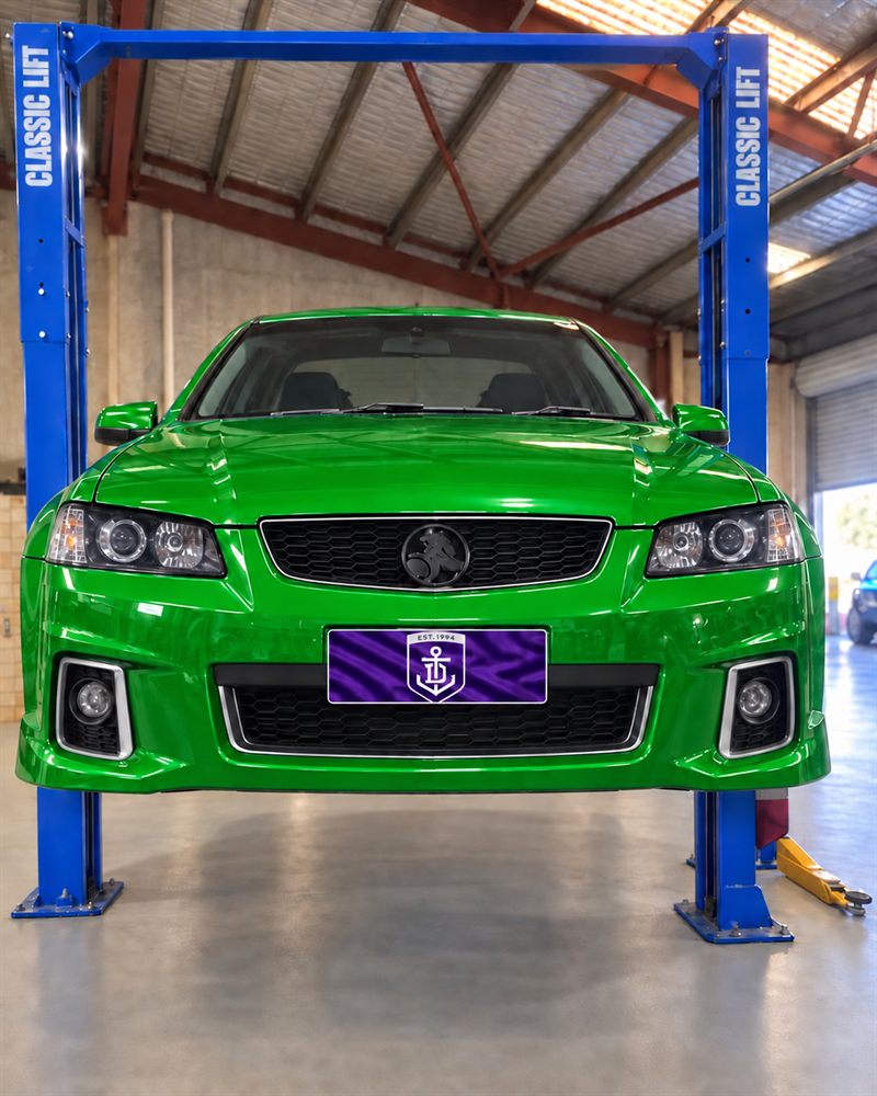 Green Holden VE Commodore SS on a two-post hoist