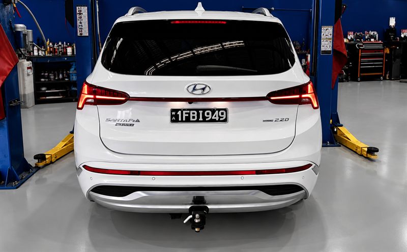 Rear view of a white Hyundai Santa Fe in a service bay