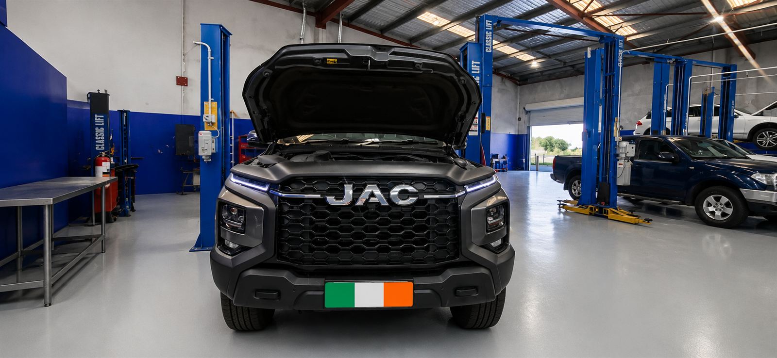 Front of a grey JAC T9 ute with its bonnet open between hoists