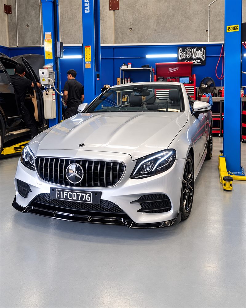Silver Mercedes-Benz E-Class cabriolet with hoists behind