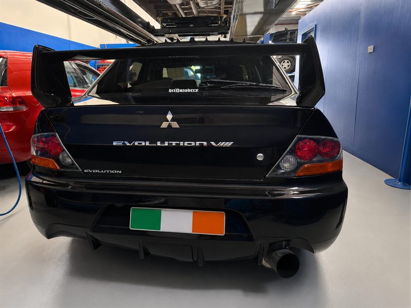 Rear of a black Mitsubishi Lancer Evolution VIII with its big wing