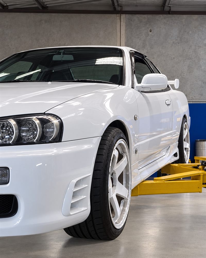 Nissan Skyline R34 side view on the workshop floor