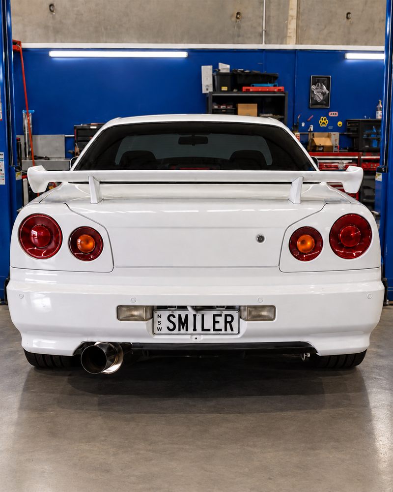 Rear view of a white Nissan Skyline R34 with its spoiler