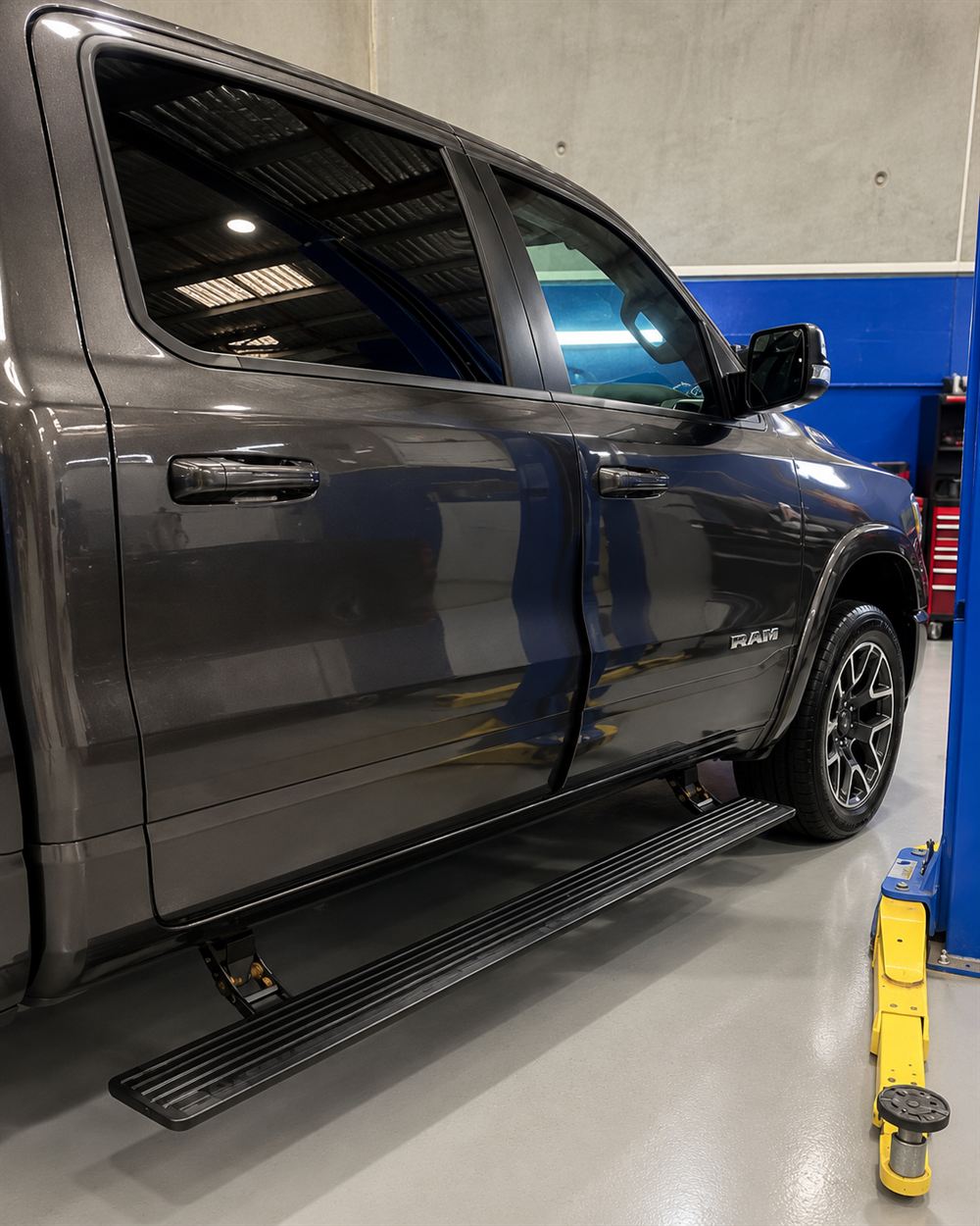 Side view of a grey RAM 1500 crew cab with power side steps