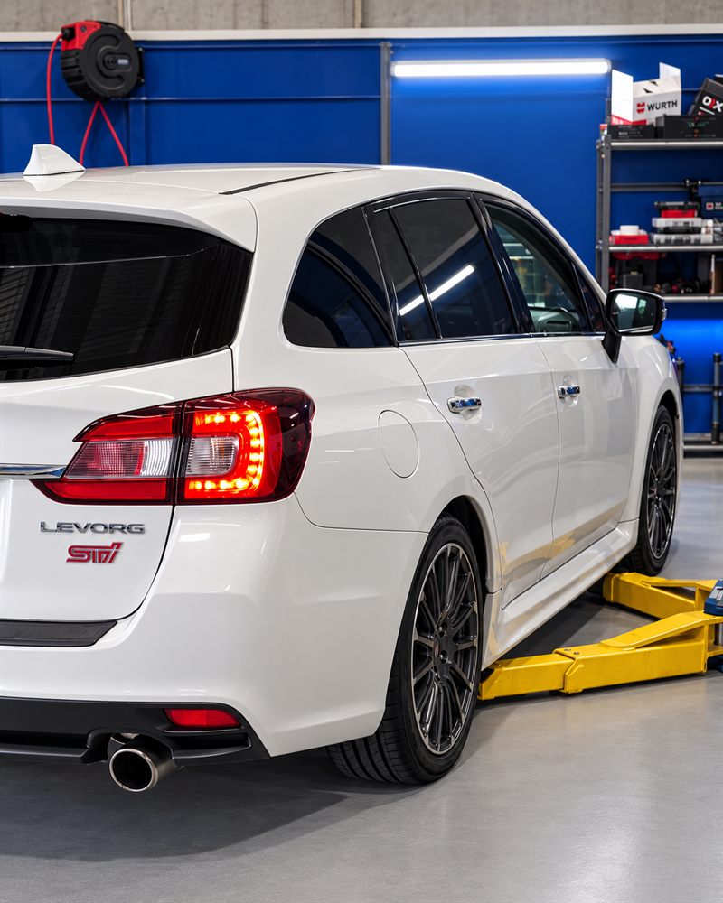 White Subaru Levorg STI on the hoist arms