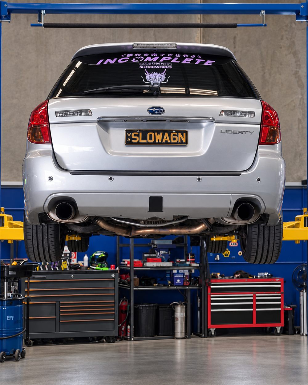 Rear of a silver Subaru Liberty wagon on the hoist