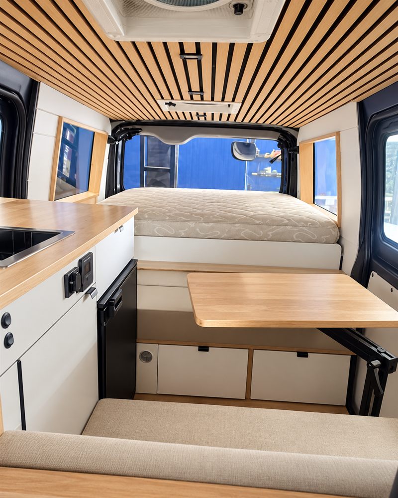 Fitted-out camper interior of a Toyota HiAce with timber ceiling
