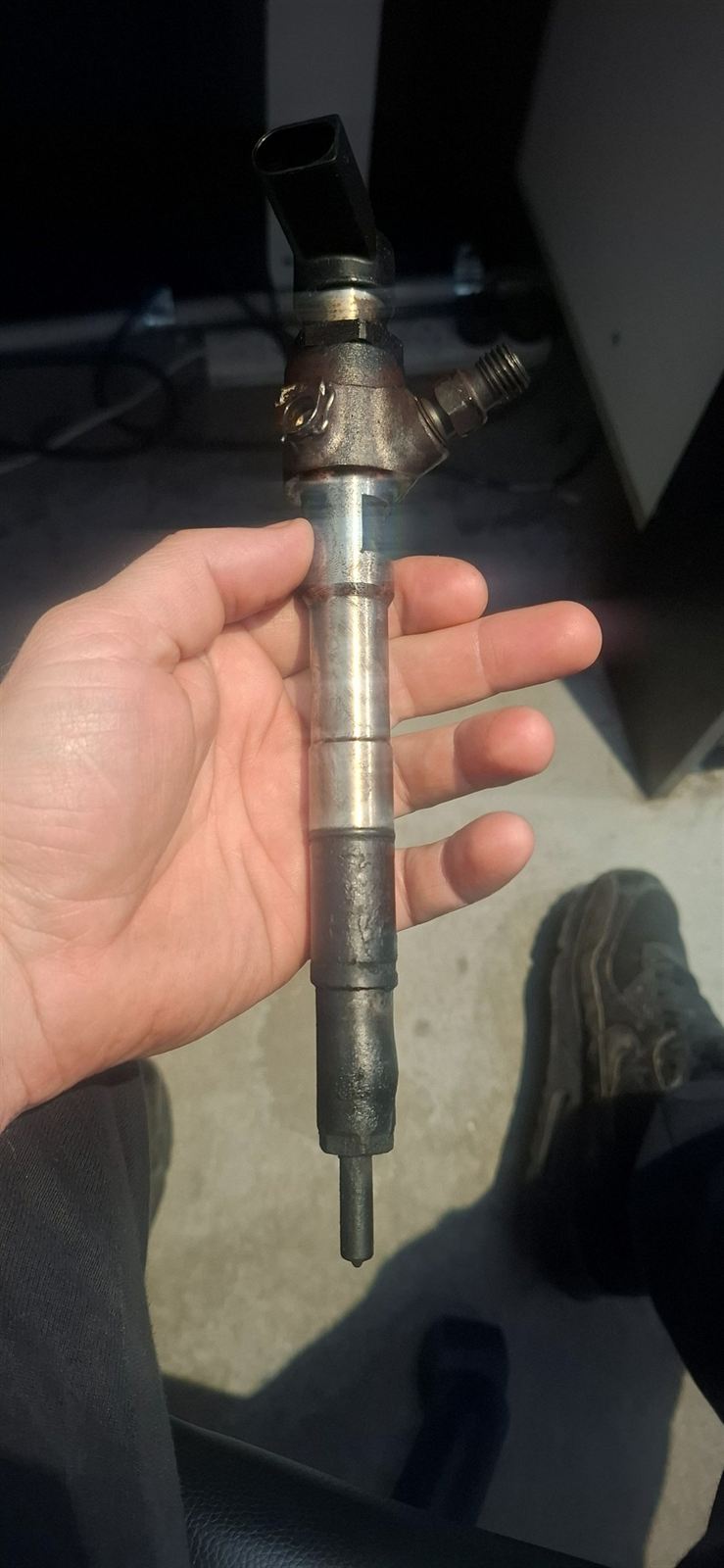 Diesel injector removed from the engine and held in hand