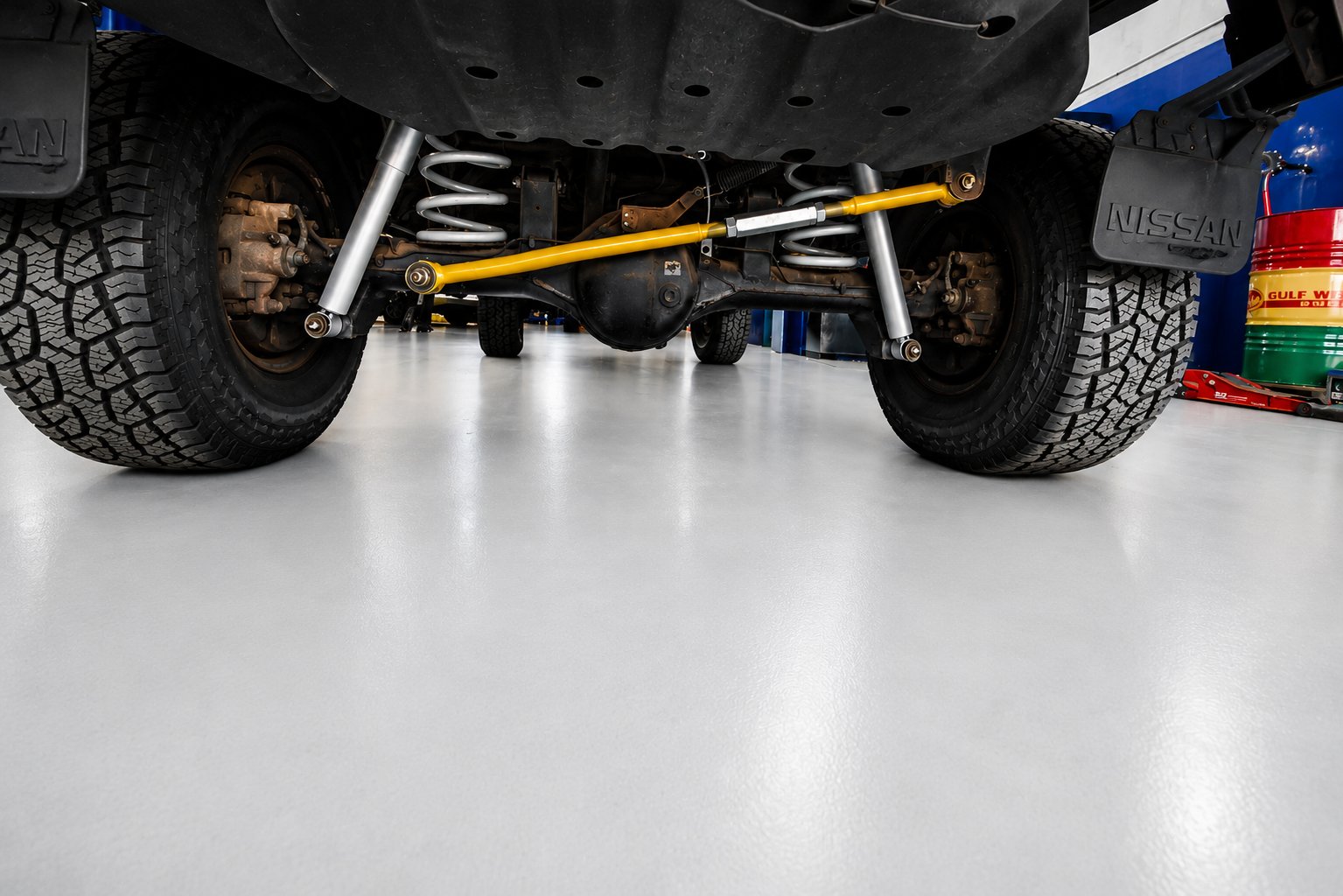 Underneath a Patrol GQ showing coil springs, shocks and a yellow panhard rod
