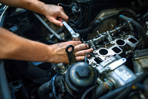 A technician diligently repairs a car engine, showcasing expertise at Malaga Car Repairs, known for quality service and competitive prices.