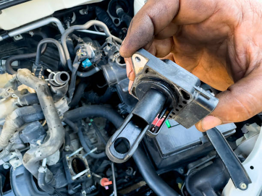 A person adjusts the fuel pump on a car engine, highlighting the importance of engine diagnostics in preventing failures.