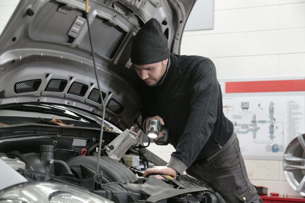 a man checking on car's engine for mechanics malaga