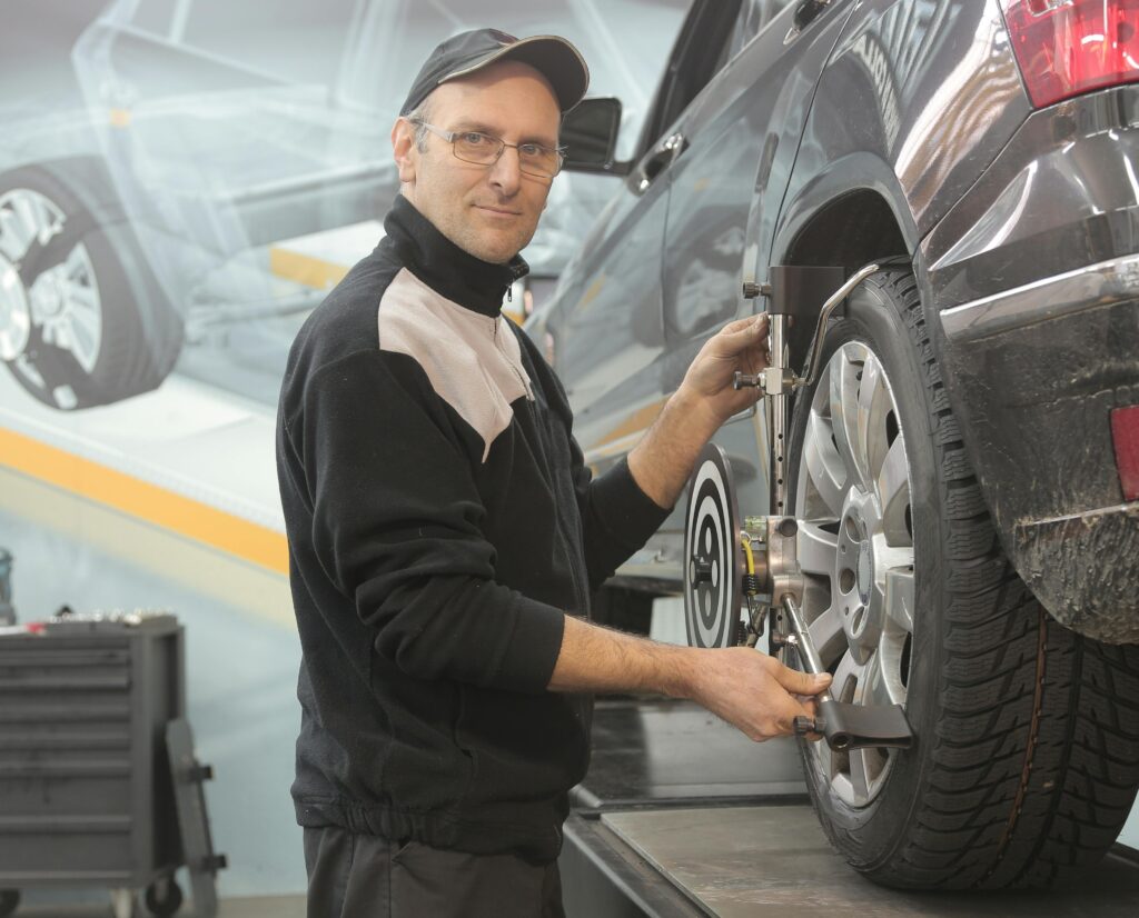 A man engaged in car maintenance, focusing on the tyres Malaga to ensure proper functionality and safety.