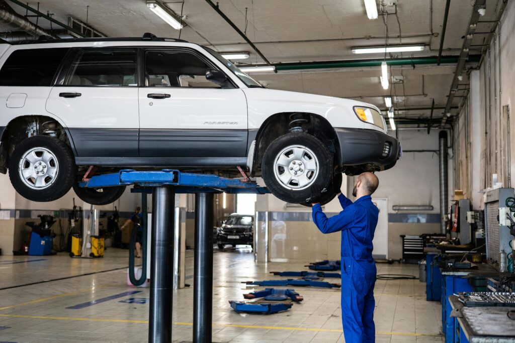 A man repairs a car in a garage, focusing on the tyres Malaga for optimal performance and safety.
