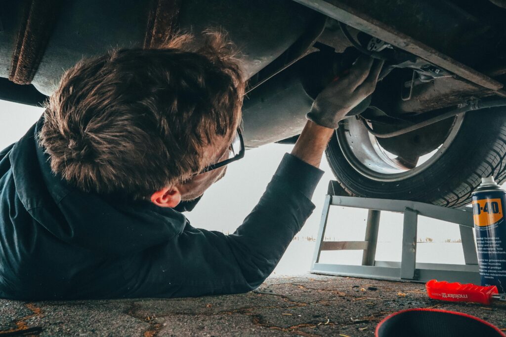a mechanic working under a car in mechanics malaga