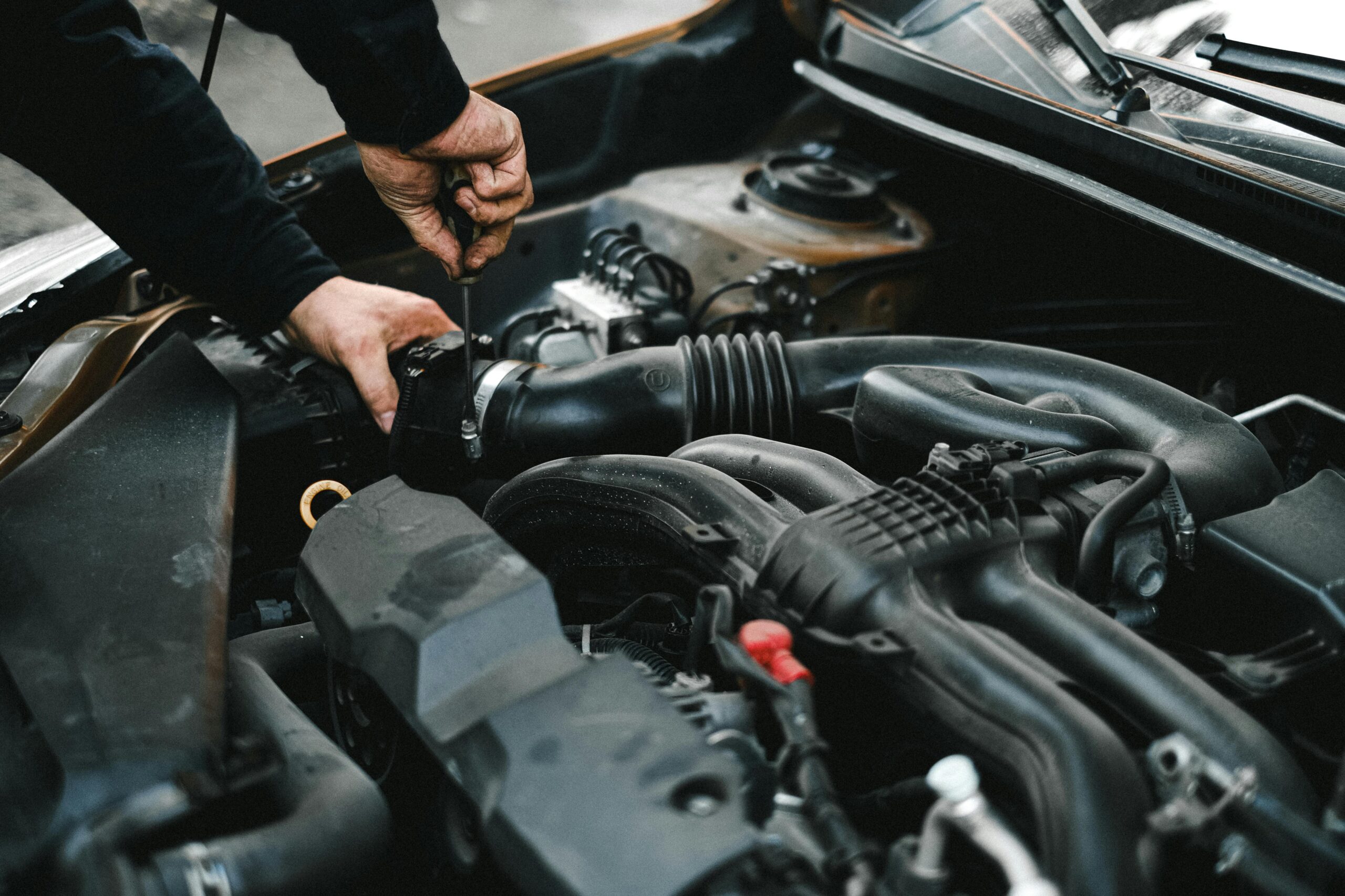 Man performing car repair on engine.